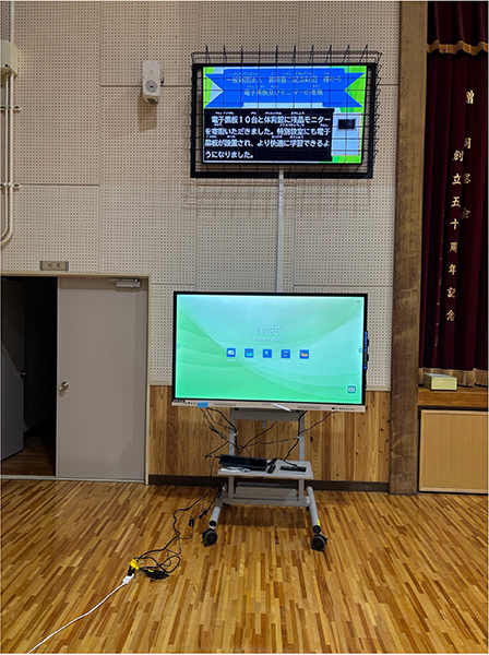 体育館に設置された電子黒板と壁掛けモニター。